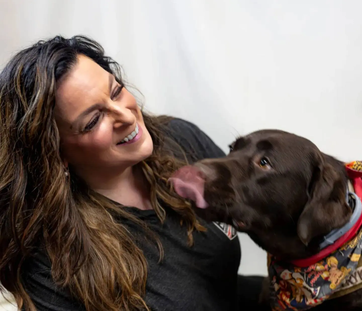 A woman and her dog are smiling for the camera.